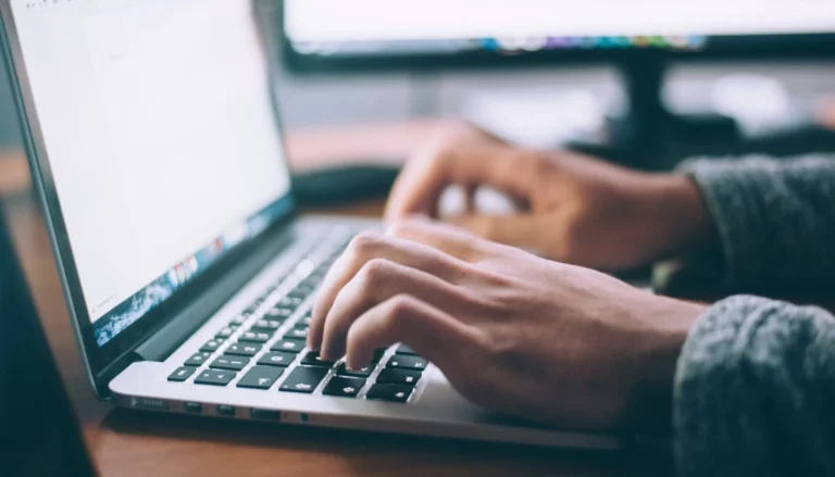 Hands typing on a laptop keyboard