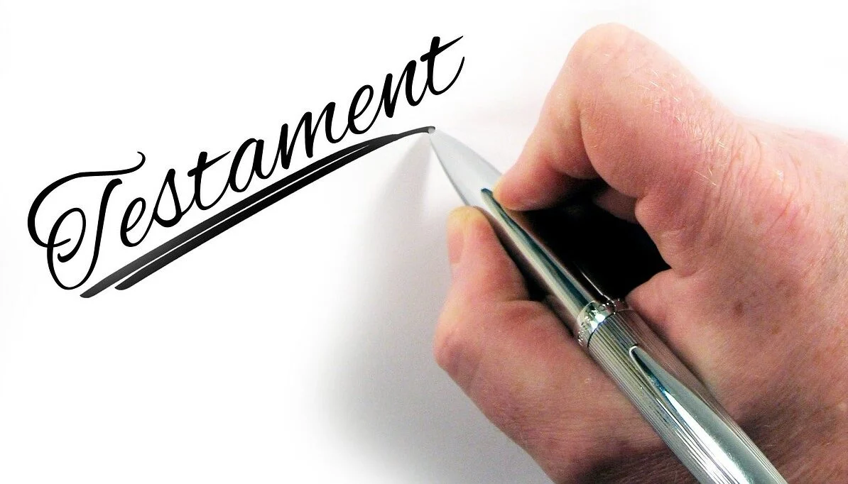 Hand writing the word Testament on paper